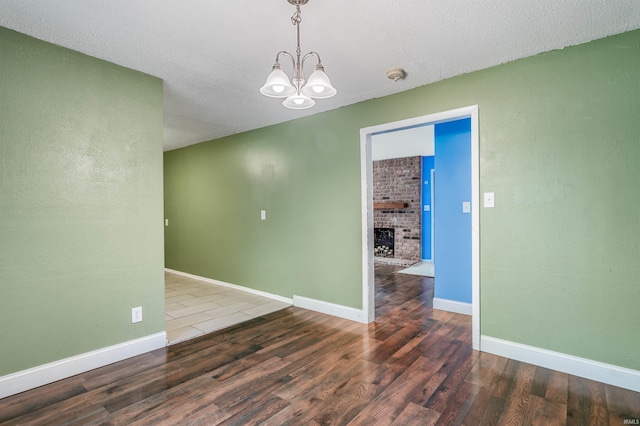 4648 Parkerdale Dr, Fort Wayne, IN 46815 - unfurnished room with a chandelier, a smoke detector, wood finished floors, a fireplace, and a textured ceiling