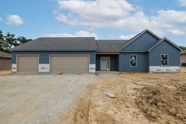 980 E Hawthorn Ln, Columbia City, IN 46725 - view of front of property featuring a shingled roof, a garage, dirt driveway, and board and batten siding