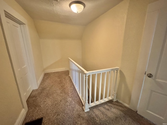 808 19th St, Logansport, IN 46947 - hallway featuring dark colored carpet, a textured ceiling, vaulted ceiling, and an upstairs landing