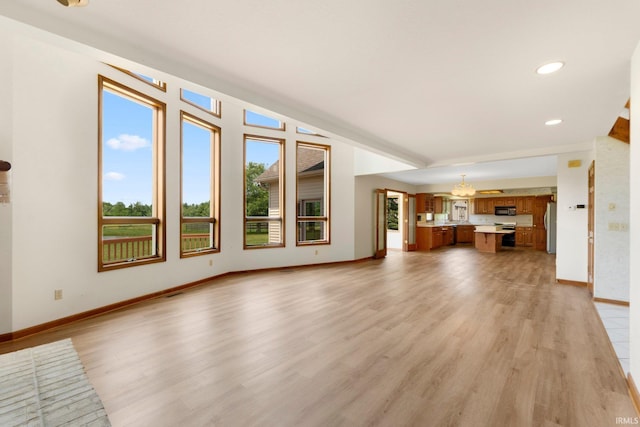 6625 Union Chapel Rd, Fort Wayne, IN 46845 - unfurnished living room featuring light wood-style flooring, a chandelier, and recessed lighting