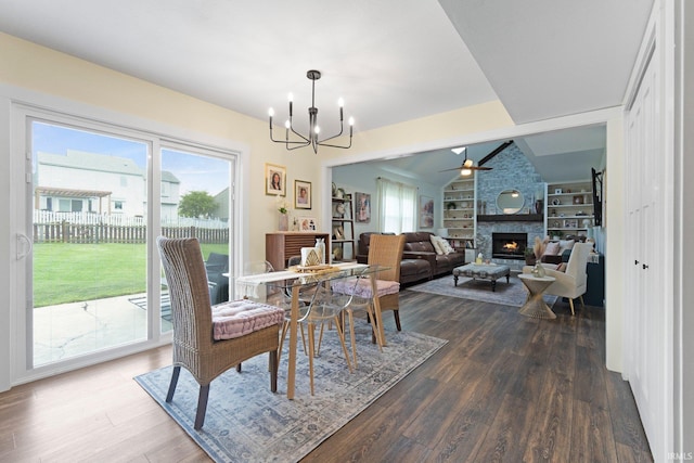 10729 Lone Tree Pl, Fort Wayne, IN 46818 - dining area with a fireplace, dark wood-type flooring, a chandelier, built in shelves, and ceiling fan
