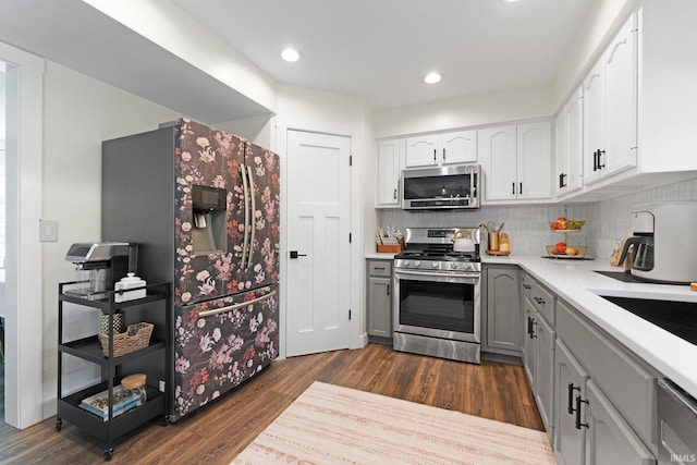 10729 Lone Tree Pl, Fort Wayne, IN 46818 - kitchen with appliances with stainless steel finishes, dark wood-style flooring, light countertops, gray cabinetry, and backsplash