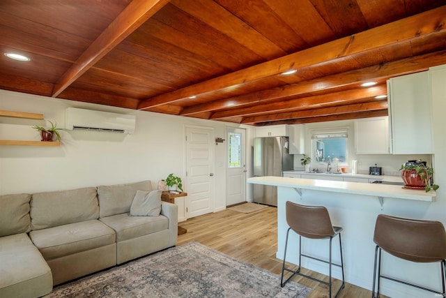 0175 Frantz Dr, Wawaka, IN 46794 - kitchen featuring a wall unit AC, freestanding refrigerator, a kitchen bar, a wooden ceiling with exposed beams, and open floor plan