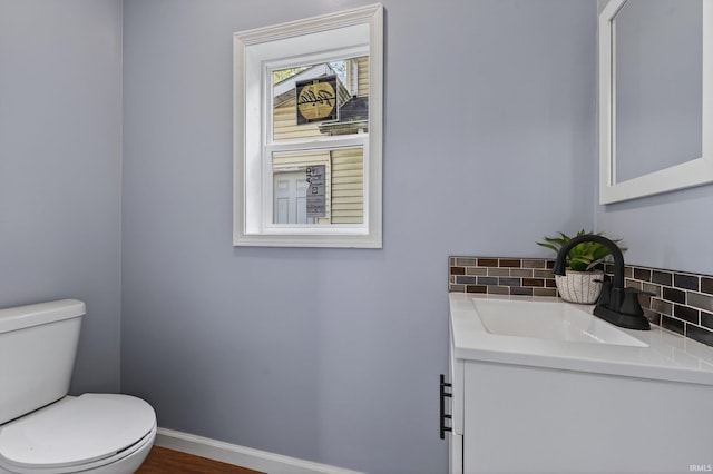 669 W Lexington Ave, Elkhart, IN 46514 - half bathroom with vanity, tasteful backsplash, and wood finished floors