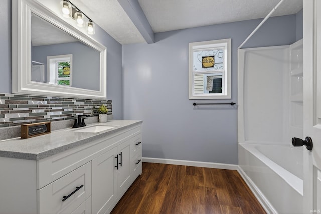 669 W Lexington Ave, Elkhart, IN 46514 - full bathroom featuring vanity, wood finished floors, backsplash, and  shower combination