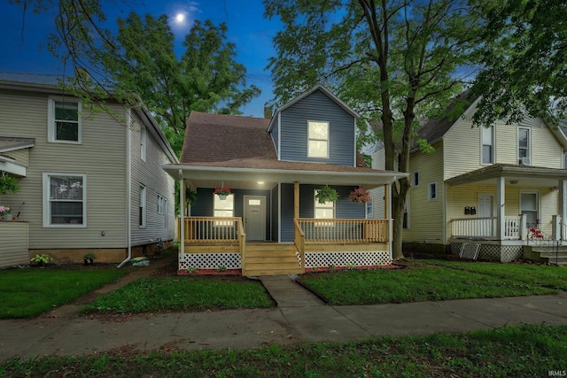669 W Lexington Ave, Elkhart, IN 46514 - view of front of home with covered porch, a front lawn, and roof with shingles