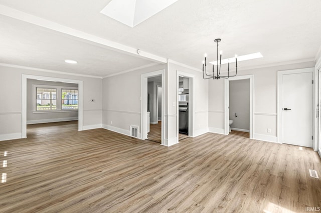 533 Altgeld St, South Bend, IN 46614 - unfurnished living room with a skylight, a chandelier, crown molding, and light wood-style floors