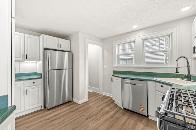 533 Altgeld St, South Bend, IN 46614 - kitchen featuring stainless steel appliances, a textured ceiling, light wood finished floors, white cabinetry, and recessed lighting