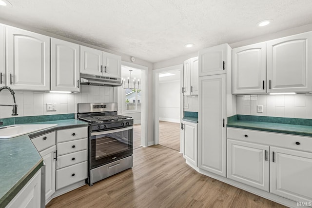 533 Altgeld St, South Bend, IN 46614 - kitchen featuring stainless steel gas stove, under cabinet range hood, a textured ceiling, light wood-style flooring, and tasteful backsplash
