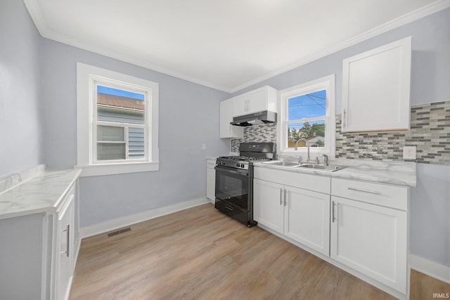 3014 Drexel Ave, Fort Wayne, IN 46806 - kitchen with black range with gas stovetop, under cabinet range hood, backsplash, light wood-style floors, and ornamental molding