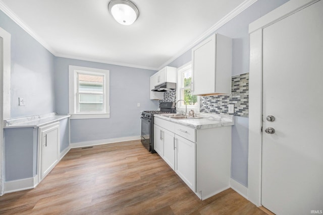 3014 Drexel Ave, Fort Wayne, IN 46806 - kitchen featuring black range with gas cooktop, under cabinet range hood, crown molding, plenty of natural light, and tasteful backsplash