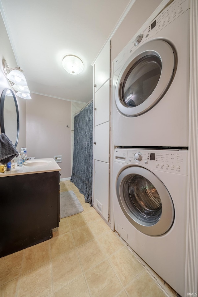 1712 Royal Center Pike, Logansport, IN 46947 - washroom featuring stacked washer and clothes dryer, ornamental molding, and light tile patterned flooring