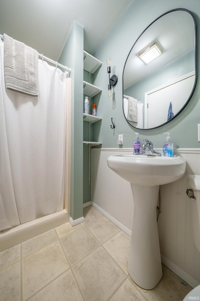 1712 Royal Center Pike, Logansport, IN 46947 - bathroom featuring a shower with shower curtain, tile patterned flooring, and a wainscoted wall