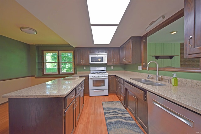 9818 Houndshill Pl, Fort Wayne, IN 46804 - kitchen with white appliances, light wood-style flooring, a kitchen island, light stone counters, and dark brown cabinets