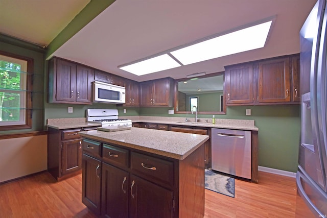 9818 Houndshill Pl, Fort Wayne, IN 46804 - kitchen featuring appliances with stainless steel finishes, light wood-style floors, a skylight, and a kitchen island