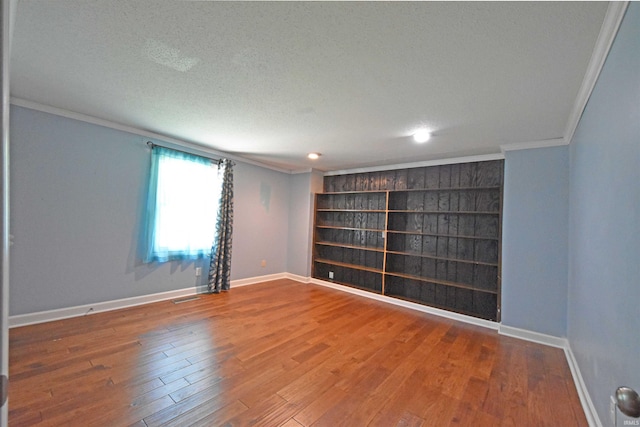 9818 Houndshill Pl, Fort Wayne, IN 46804 - empty room with crown molding, wood finished floors, a textured ceiling, recessed lighting, and built in features
