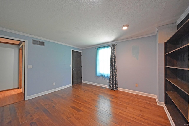 9818 Houndshill Pl, Fort Wayne, IN 46804 - empty room featuring a textured ceiling, wood finished floors, and crown molding
