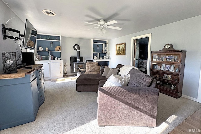 68615 County Road 23, New Paris, IN 46553 - living room featuring a wood stove, a ceiling fan, and light wood finished floors