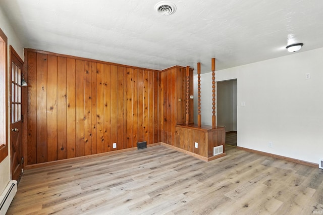 58 W Markle Rd, Huntington, IN 46750 - spare room featuring a baseboard radiator, wood finished floors, and wooden walls