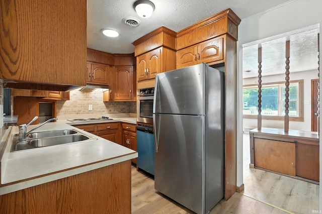 58 W Markle Rd, Huntington, IN 46750 - kitchen with appliances with stainless steel finishes, under cabinet range hood, light wood-type flooring, backsplash, and brown cabinets