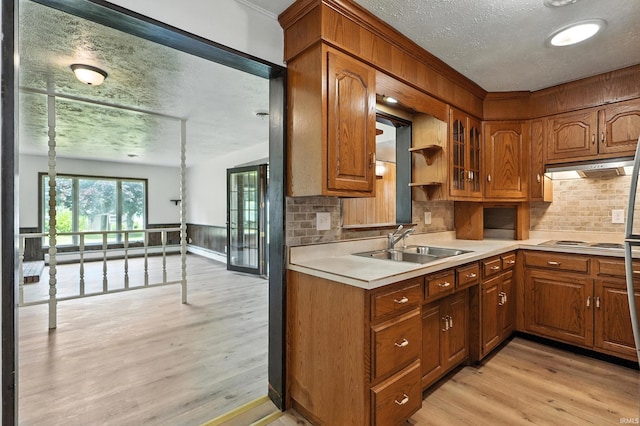 58 W Markle Rd, Huntington, IN 46750 - kitchen with a textured ceiling, under cabinet range hood, light wood-style floors, light countertops, and decorative backsplash