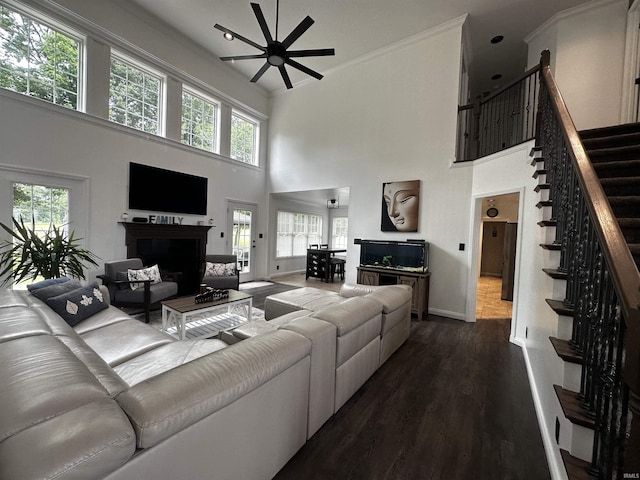 2939 Charlestown Ct, Evansville, IN 47725 - living area featuring a fireplace, ceiling fan, stairs, dark wood-style flooring, and a towering ceiling