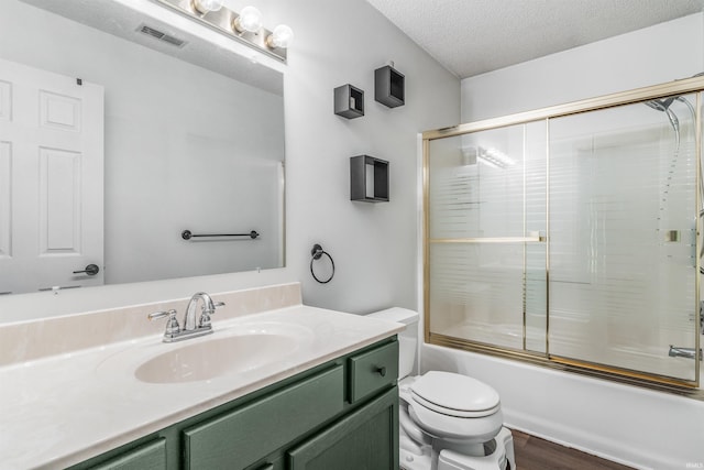 606 Larch Ln, Fort Wayne, IN 46825 - bathroom featuring vanity, enclosed tub / shower combo, a textured ceiling, and wood finished floors