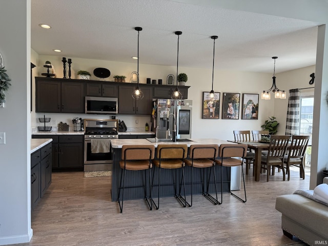 12788 Kingfish Ct, Middlebury, IN 46540 - kitchen with appliances with stainless steel finishes, light countertops, a breakfast bar, light wood-style flooring, and recessed lighting