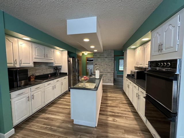 1701 Fairway Dr, Kokomo, IN 46901 - kitchen featuring black appliances, dark countertops, a textured ceiling, tasteful backsplash, and dark wood-type flooring