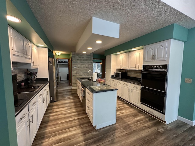 1701 Fairway Dr, Kokomo, IN 46901 - kitchen with black appliances, dark countertops, a textured ceiling, dark wood-style flooring, and backsplash