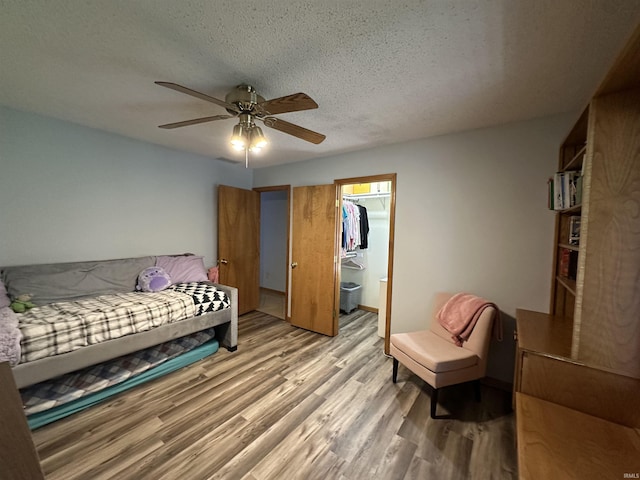 1701 Fairway Dr, Kokomo, IN 46901 - bedroom with light wood-style floors, a textured ceiling, a ceiling fan, a spacious closet, and a closet