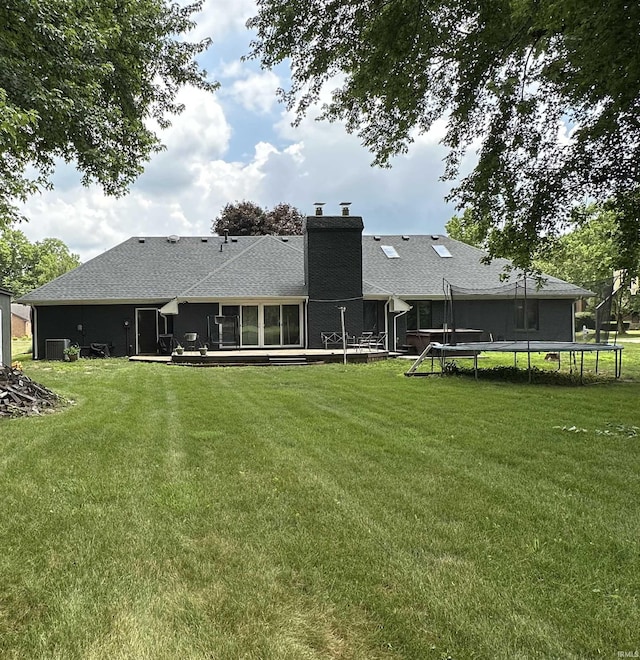 1701 Fairway Dr, Kokomo, IN 46901 - back of house featuring a trampoline, a lawn, and a chimney