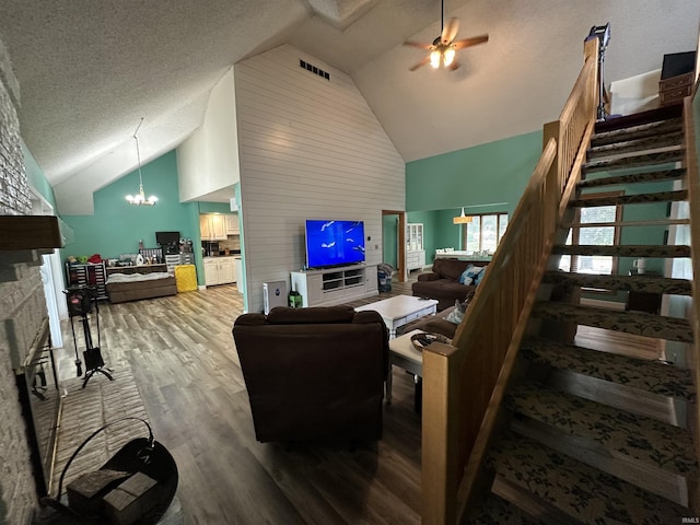 1701 Fairway Dr, Kokomo, IN 46901 - living area featuring wood finished floors, high vaulted ceiling, stairs, a ceiling fan, and a fireplace with raised hearth