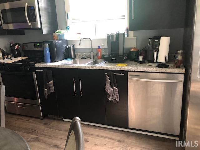 1124 N Maple St, Richland, IN 47634 - kitchen with stainless steel appliances, light wood-type flooring, light countertops, and dark cabinets