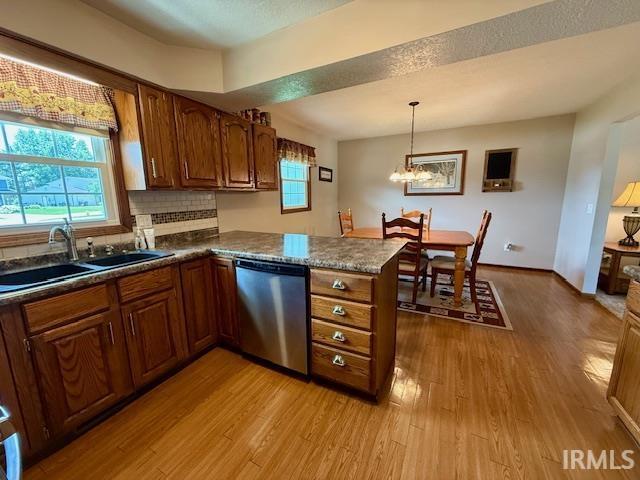 9910 Quachita Ct, Fort Wayne, IN 46804 - kitchen with dishwasher, wood finished floors, a peninsula, brown cabinetry, and decorative backsplash