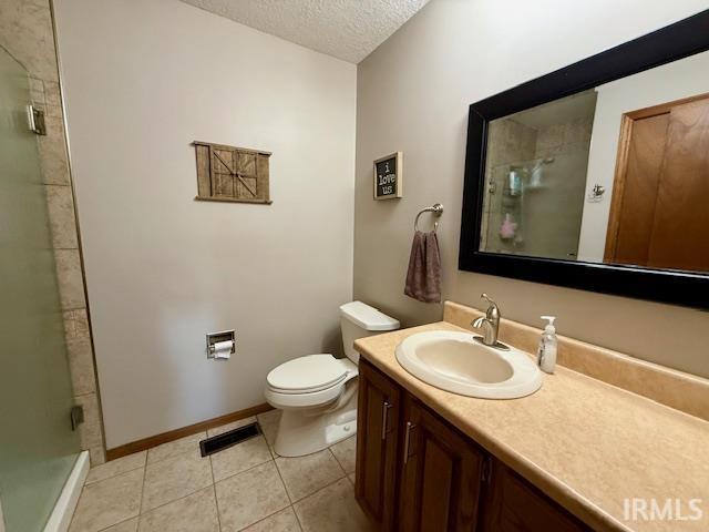 9910 Quachita Ct, Fort Wayne, IN 46804 - bathroom with a textured ceiling, vanity, an enclosed shower, and tile patterned flooring