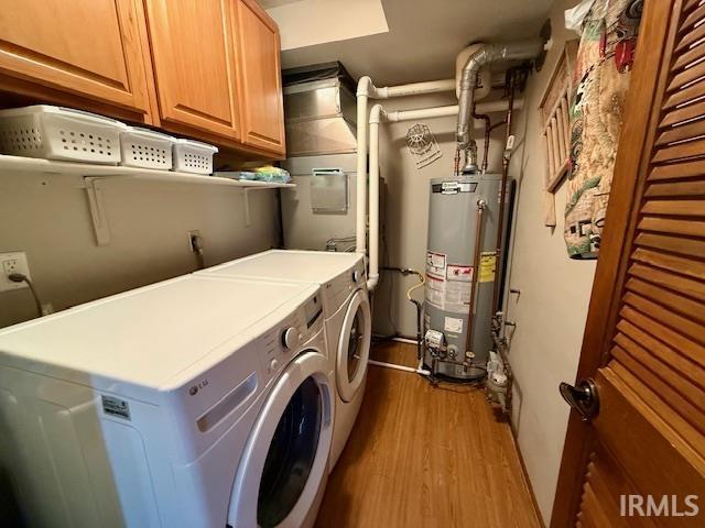 9910 Quachita Ct, Fort Wayne, IN 46804 - laundry area featuring water heater, washing machine and clothes dryer, wood finished floors, and cabinet space
