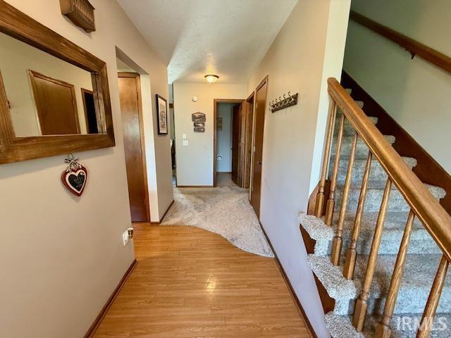 9910 Quachita Ct, Fort Wayne, IN 46804 - hallway featuring stairway and light wood-style flooring
