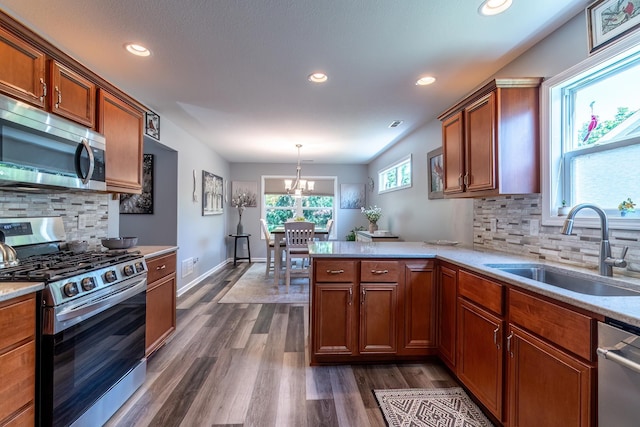 1709 Krebs Ct, Angola, IN 46703 - kitchen featuring appliances with stainless steel finishes, brown cabinets, a peninsula, light countertops, and dark wood finished floors