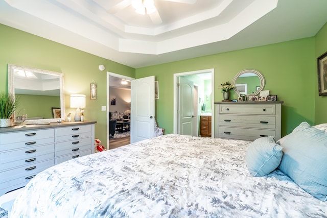 1709 Krebs Ct, Angola, IN 46703 - bedroom with a tray ceiling, connected bathroom, and ceiling fan