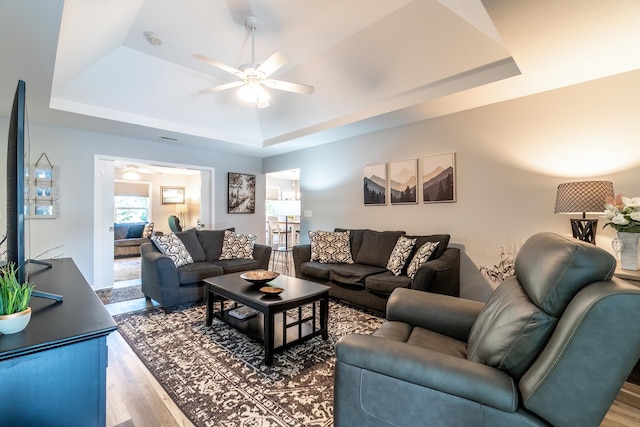 1709 Krebs Ct, Angola, IN 46703 - living area featuring a tray ceiling, wood finished floors, and a ceiling fan