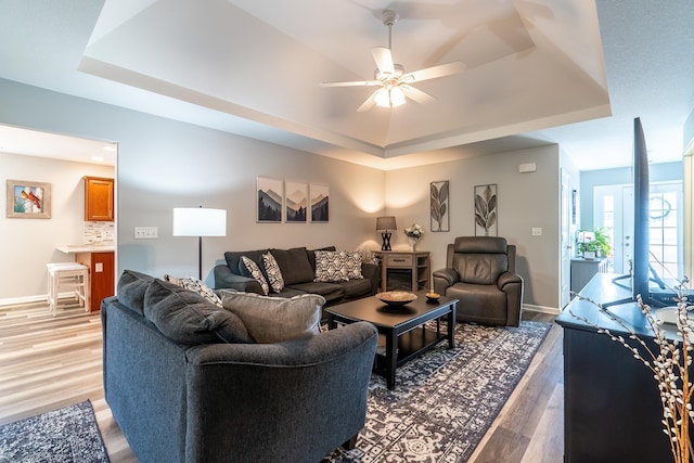 1709 Krebs Ct, Angola, IN 46703 - living area featuring a tray ceiling, light wood-type flooring, and a ceiling fan