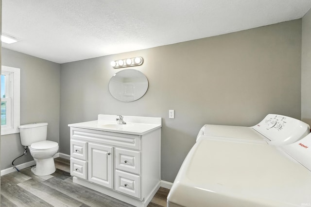 615 E Main St, Butler, IN 46721 - bathroom featuring washing machine and dryer, vanity, wood finished floors, and a textured ceiling