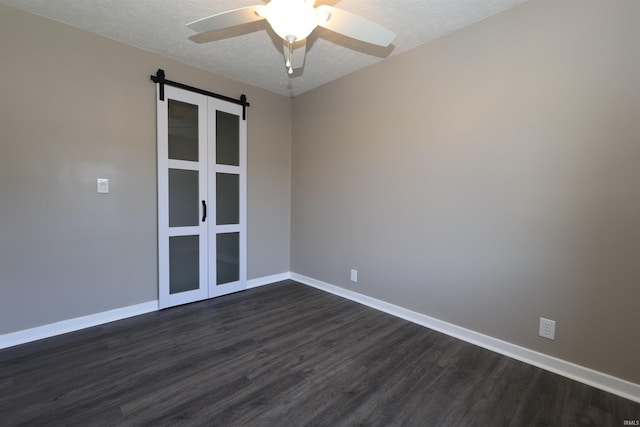 2114 S Branson St, Marion, IN 46953 - unfurnished room featuring dark wood-style floors, a textured ceiling, ceiling fan, and a barn door