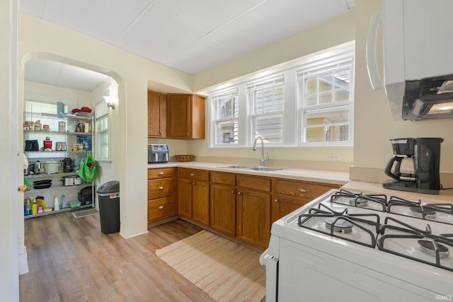 2001 N Anthony Blvd, Fort Wayne, IN 46805 - kitchen featuring brown cabinetry, light wood-type flooring, light countertops, and white gas stove