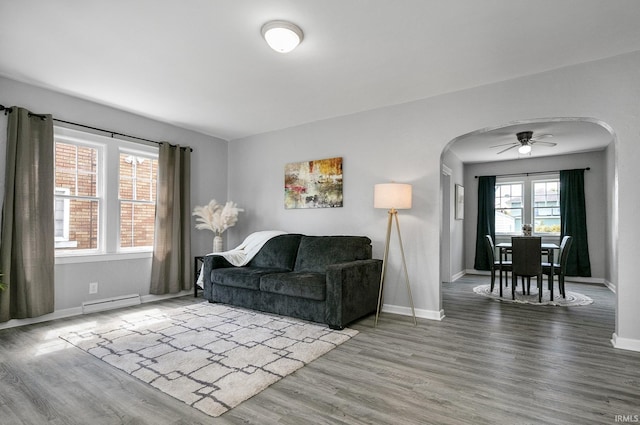 2606 Prast Blvd, South Bend, IN 46628 - living room with arched walkways, baseboard heating, wood finished floors, and a ceiling fan