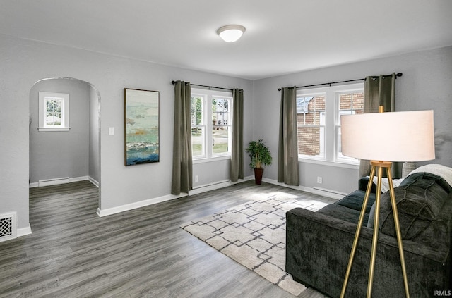 2606 Prast Blvd, South Bend, IN 46628 - living area featuring arched walkways, wood finished floors, a baseboard radiator, and baseboard heating