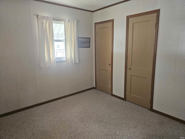 207 E Columbia St, Logansport, IN 46947 - unfurnished bedroom featuring crown molding, wallpapered walls, and carpet floors