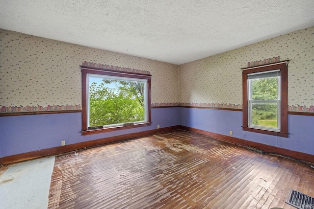 3192 N 150 W, Kokomo, IN 46901 - unfurnished room with a textured ceiling, plenty of natural light, hardwood / wood-style flooring, and wallpapered walls