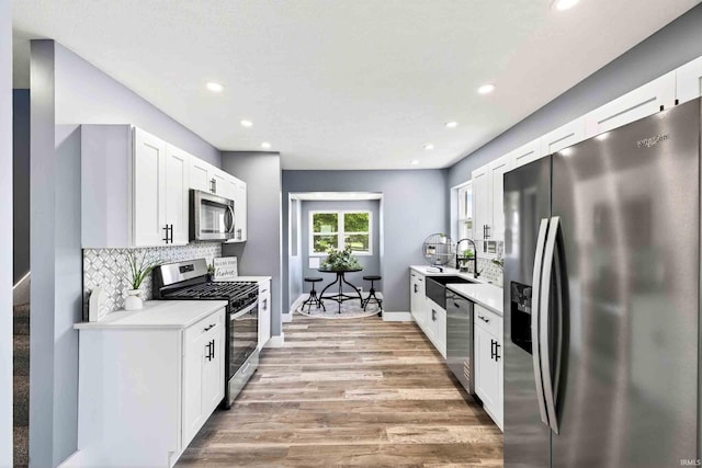 120 Lincoln Ave, Bedford, IN 47421 - kitchen featuring stainless steel appliances, light wood finished floors, tasteful backsplash, light countertops, and recessed lighting